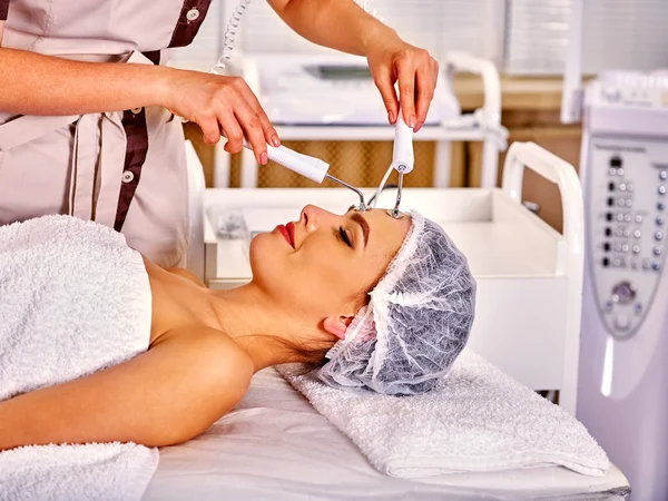 Mujer joven recibiendo masaje facial eléctrico . —  Fotos de Stock