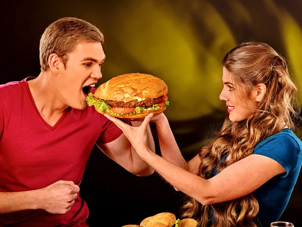 Mujer alimenta hombre comida rápida . — Foto de Stock