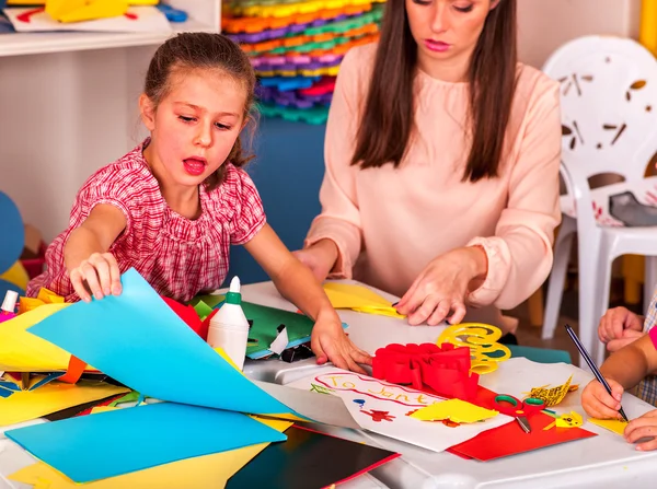 Little girl with teacher woman painting on paper in  kindergarten . — Stock Photo, Image