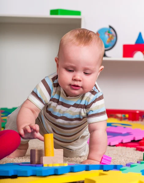 Dziecko, chłopca kursujące z puzzle zabawki na podłodze. — Zdjęcie stockowe
