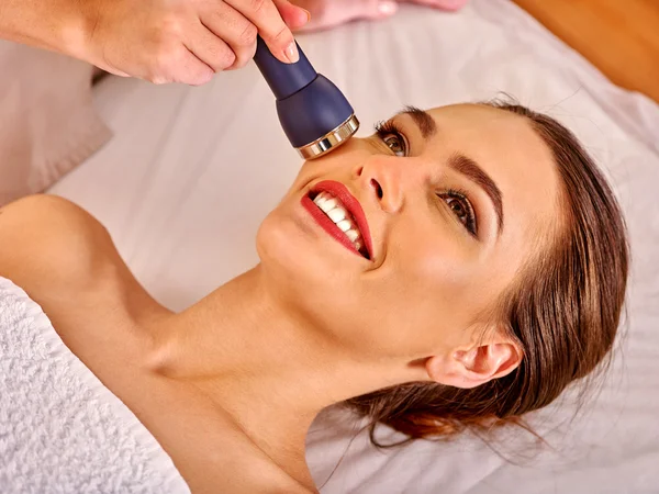 Ung kvinna tar emot elektriska ansiktsmassage. — Stockfoto