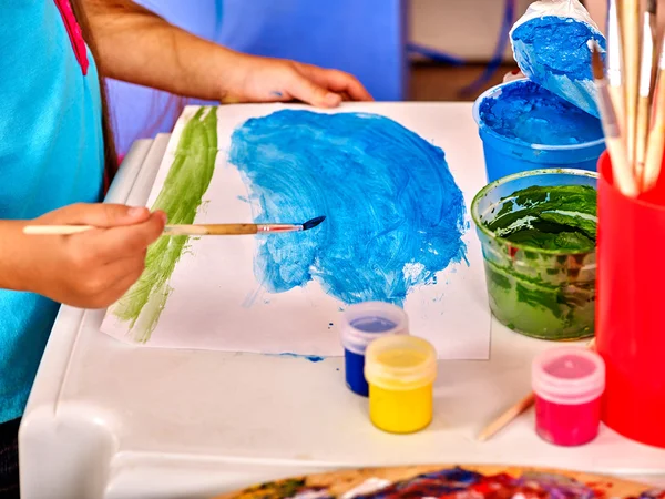 Mãos de criança com pintura de escova na mesa no jardim de infância  . — Fotografia de Stock