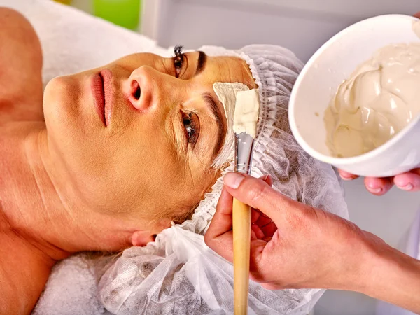 Mujer de mediana edad tomar masaje facial en el salón de spa . — Foto de Stock