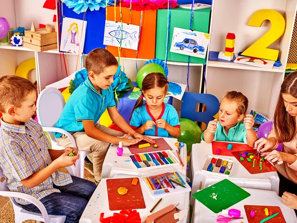 Grupo de niños molde de plastilina en el jardín de infantes  . — Foto de Stock