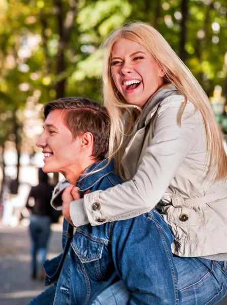 Pareja joven abrazándose y coqueteando en el parque de primavera . — Foto de Stock