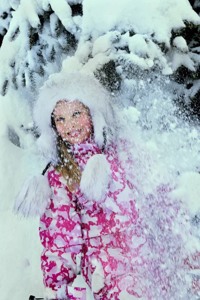 Little kid girl in winter clothes with falling snow on face. — Stock Photo, Image