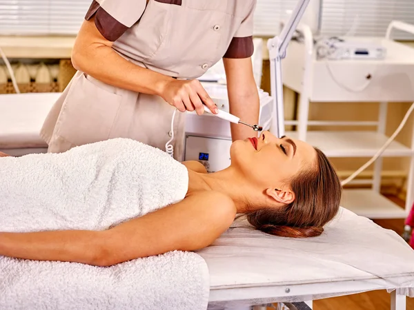 Jovem recebendo massagem facial elétrica . — Fotografia de Stock