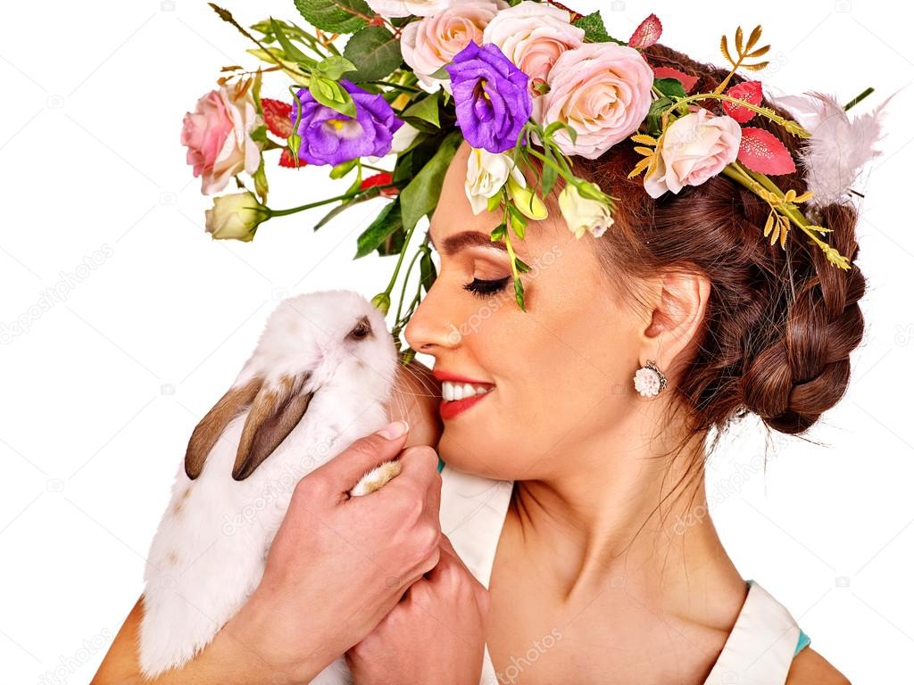 Woman in easter style holding eggs and flowers.