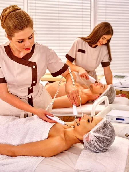 Familia recibiendo masaje facial eléctrico — Foto de Stock