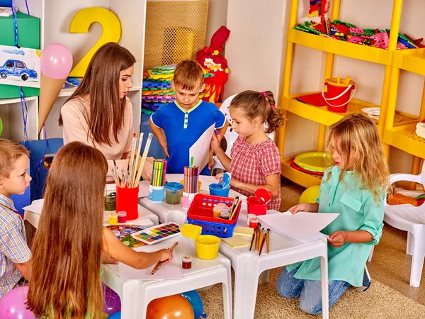 Kinderen met leraar schilderen op papier — Stockfoto