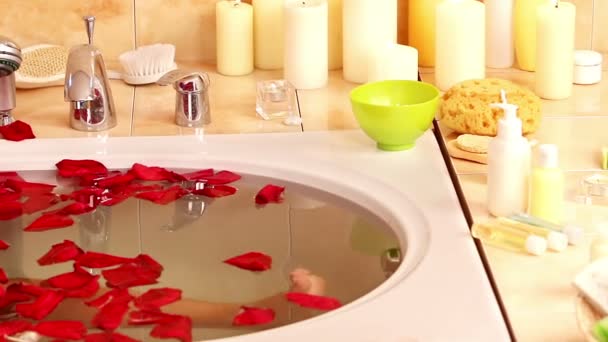 Dziewczyna biorąc kąpiel z płatków róży. — Wideo stockowe