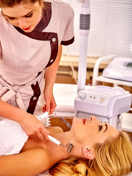 Mujer joven recibiendo masaje facial eléctrico . — Foto de Stock