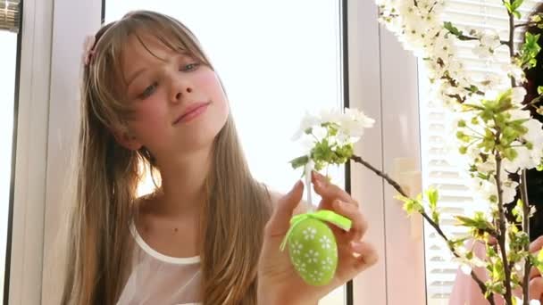 Child hang easter egg on cherry branch. — Stock Video