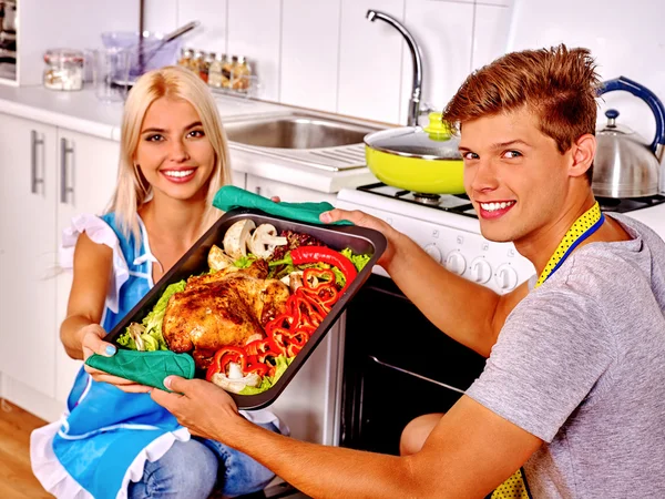 Casal cozinhar frango na cozinha . — Fotografia de Stock