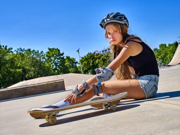 Ragazza sportiva con lesioni vicino al suo skateboard all'aperto . — Foto Stock