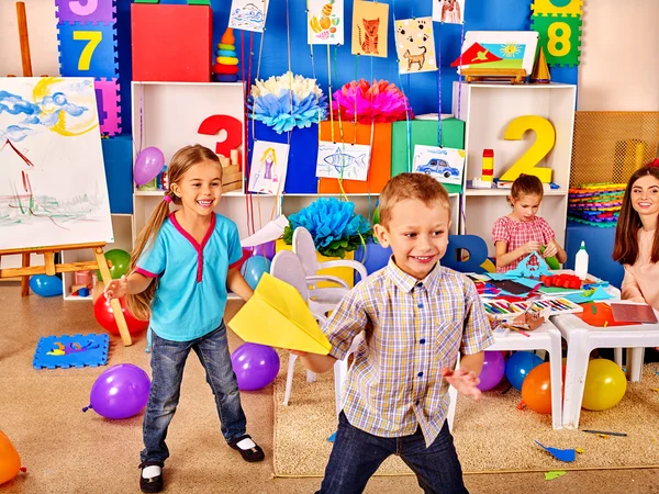 Groep kinderen houden van origami vliegtuig in de kleuterschool. — Stockfoto