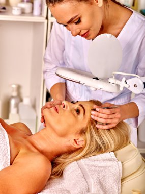 Spa salonda orta yaşlı kadın. Güzellik uzmanı tarafından tweezing kaş.