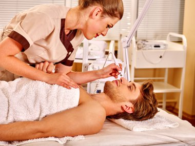 Adam elektrik yüz masajı alma.