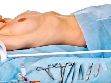 Çıplak kadın vücudu arka plan üzerinde cerrahi aletler.