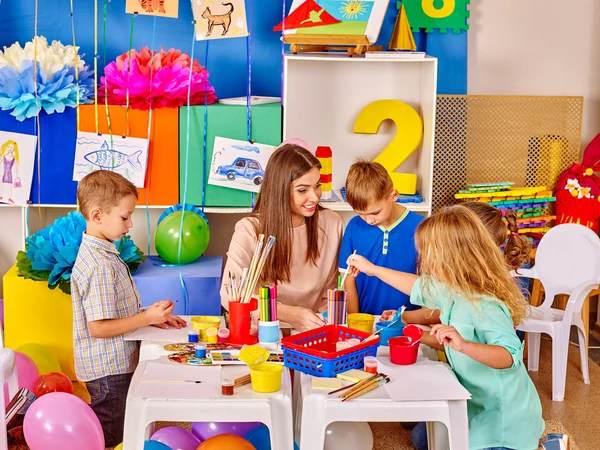 Groep van kinderen met vrouwelijke leraar schilderij samen . — Stockfoto