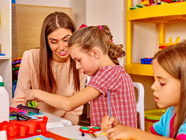 Lehrerin bringt Kindern bei, wie man Origami macht . — Stockfoto