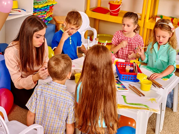 Crianças com professor mulher pintura no papel no jardim de infância  . — Fotografia de Stock