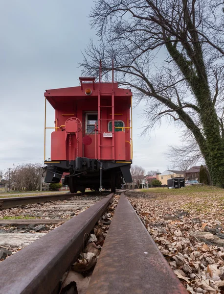 Старый красный вагон с железнодорожными путями — стоковое фото