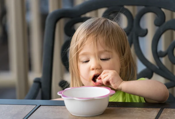 Malá holčička jíst z misky — Stock fotografie