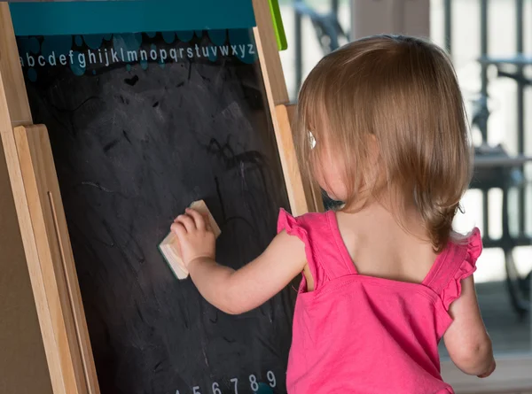 Niña limpiando una pizarra — Foto de Stock