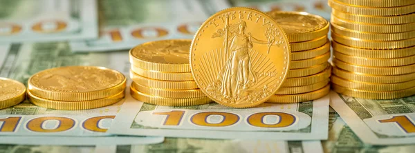 Gouden munten op nieuwe ontwerp 100 dollarbiljetten gestapeld — Stockfoto