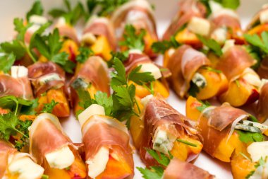 Birçok küçük şeftali ve gorgonzola prosciutto aperatifler sarılmış