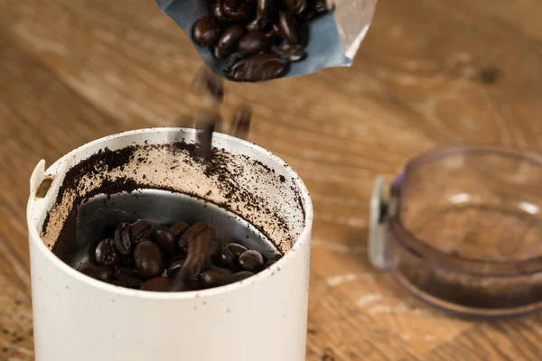 Café molido en amoladora sobre mesa de madera — Foto de Stock