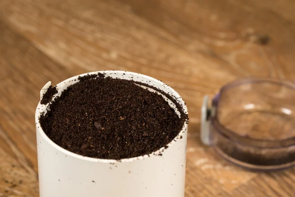 Café molido en amoladora sobre mesa de madera — Foto de Stock