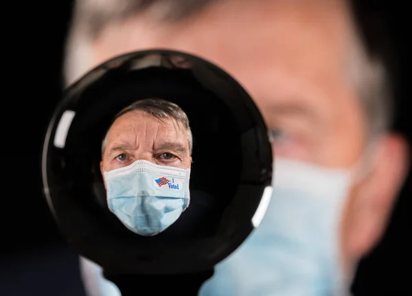 Senior man wearing a medical mask and I Voted sticker inside a glass crystal ball — Stock Photo, Image