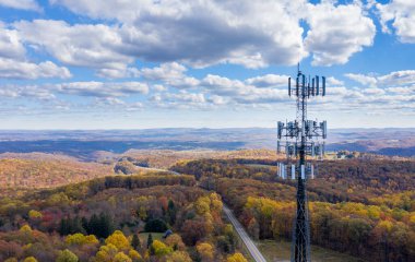 Cell phone or mobile service tower in forested area of West Virginia providing broadband service clipart