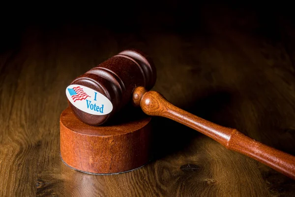 私は投票に関する訴訟を説明するために、ギャベルとマレットでキャンペーンボタンやステッカーに投票しました — ストック写真