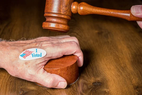 Ik stemde campagne knop of sticker bij de hand met een hamer en hamer om rechtszaken over stemmen te illustreren — Stockfoto