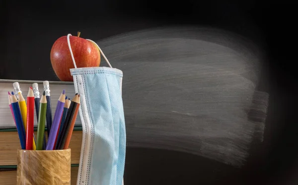 Retour à l'école virtuelle concept de fond avec pile de livres, crayon, pomme avec masque facial — Photo