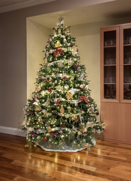 Árvore de Natal ornatamente decorada no canto de uma sala de família moderna — Fotografia de Stock