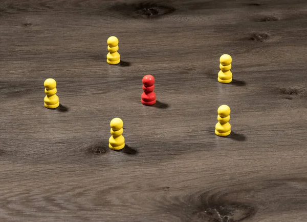 Żółte drewniane kołki otaczające czerwony jeden, aby zilustrować przywództwo lub komunikacji mediów społecznościowych — Zdjęcie stockowe