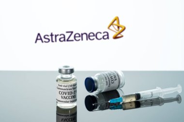 Beyaz AstraZeneca arka planına yansıtılan şırıngalı Covid-19 aşısı.