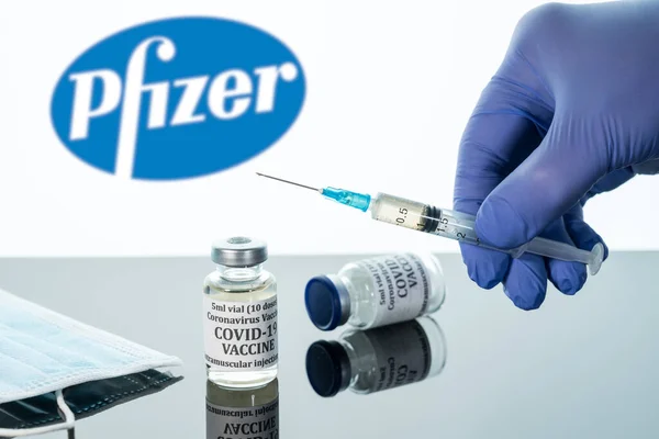 Covid-19 vaccin i injektionsflaska med spruta reflekterad mot vit Pfizer bakgrund — Stockfoto