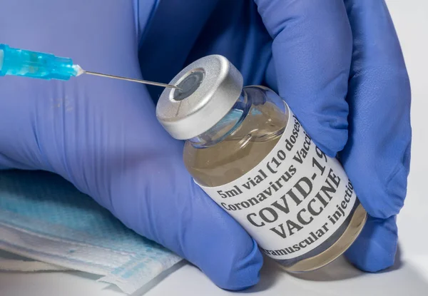 Close up of the end of the hypodermic syringe being inserted into bottle of vaccine — Stock Photo, Image