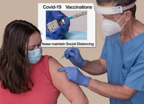 Dokter laki-laki senior memvaksinasi seorang wanita muda di klinik untuk coronavirus — Stok Foto
