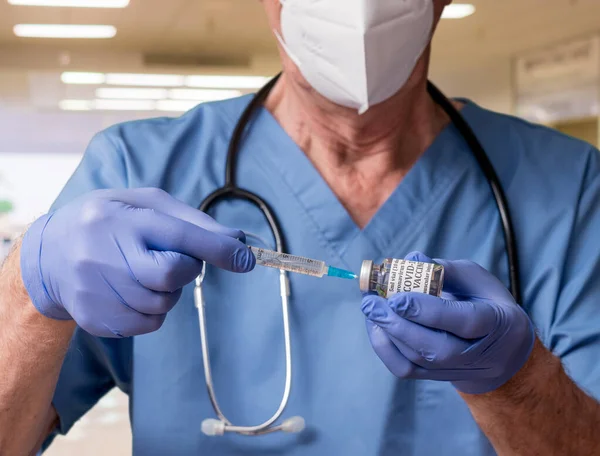 Senior male doctor taking dose of Covid-19 vaccine from bottle — Stock Photo, Image