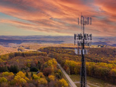 Cell phone or mobile service tower in forested area of West Virginia providing broadband service clipart