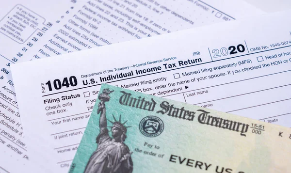 US Treasury check for stimulus in 2020 against a USA Form 1040 — Stock Photo, Image