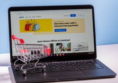 Shopping cart in front of computer screen for Affirm buy now pay later app