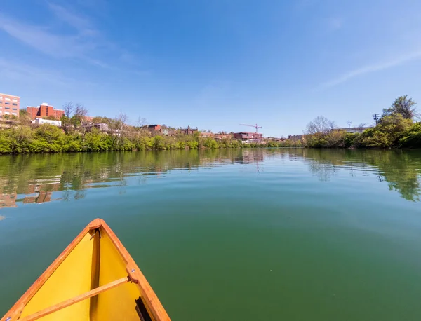 Hombre en canoa pequeña mochila amarilla remando por el río Monongahela en Morgantown — Foto de Stock