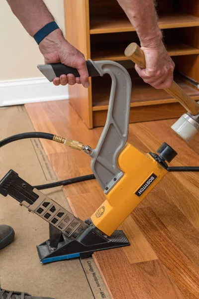 Hoge druk spijkerpistool klaar om te installeren delen van Braziliaanse Cherry hardhouten vloeren — Stockfoto